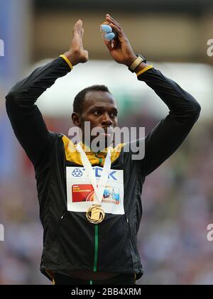 Il bullone di Usain della Giamaica celebra con la sua medaglia d'oro dopo aver vinto i 200 metri degli uomini Foto Stock