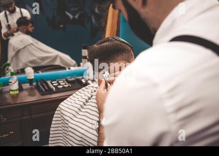 Il ragazzo fa un taglio di capelli nel barbiere Foto Stock