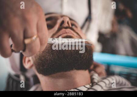 Barba e taglio. Barba e braccio con forbici. Concetto di barbiere Foto Stock