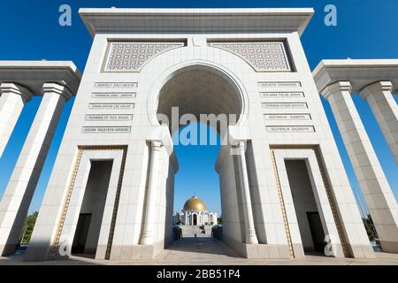 Vista simmetrica della Moschea di Ruhy del Turkmenistan enorme portico e colonne e l'antico mausoleo del presidente Saparmurat Niyazov ad Ashgabat, Turkmenistan. Foto Stock