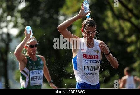 Il medalista russo d'argento Mikhail Ryzhov si raffredda come l'eventuale vincitore irlandese Robert Heffernan segue nella gara a piedi maschile 50km durante il quinto giorno dei Campionati mondiali di atletica leggera IAAF 2013 allo stadio Luzhniki di Mosca, Russia. Foto Stock