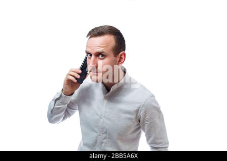 Uomo d'affari caucasico, mentore insegnante, parlare al telefono e fare un selfie. Indossa una camicia. Ritratto emozionale. Isolato su dorso bianco Foto Stock