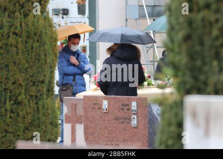 Valsugana, Italia. 30th marzo 2020. Coronavirus Pandemic - celebrazione funeraria al cimitero di Pergine Valsugana, Italia, il 30 marzo 2020. Un funerale è celebrato in un cimitero con un numero limitato di persone, alcune delle quali indossano maschere. La maggior parte dell’Europa è in fase di blocco per cercare di rallentare la diffusione della pandemia di coronavirus. (Foto di Pierre Teyssot/ESPA-Images) credito: Agenzia fotografica sportiva europea/Alamy Live News Foto Stock