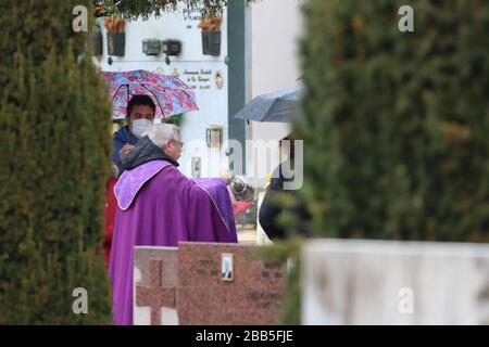 Valsugana, Italia. 30th marzo 2020. Coronavirus Pandemic - celebrazione funeraria al cimitero di Pergine Valsugana, Italia, il 30 marzo 2020. Un funerale è celebrato in un cimitero con un numero limitato di persone, alcune delle quali indossano maschere. La maggior parte dell’Europa è in fase di blocco per cercare di rallentare la diffusione della pandemia di coronavirus. (Foto di Pierre Teyssot/ESPA-Images) credito: Agenzia fotografica sportiva europea/Alamy Live News Foto Stock