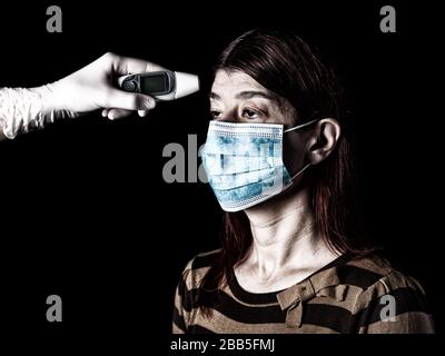donna che ha la febbre misurata o presa con termometro digitale da infermiera. Pandemia o epidemia, concetto di paura, paura o pericolo. Protezione per biohaz Foto Stock