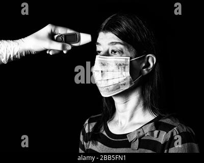donna che ha la febbre misurata o presa con termometro digitale da infermiera. Pandemia o epidemia, concetto di paura, paura o pericolo. Protezione per biohaz Foto Stock