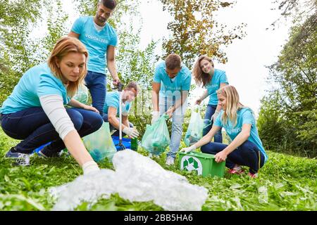 Gruppo di protezione ambientale insieme, raccogliendo rifiuti in natura Foto Stock