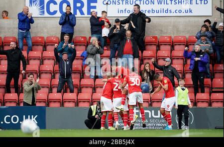 Eoin Doyle (oscurato) di Swindon Town celebra il suo primo gol con i compagni di squadra Foto Stock