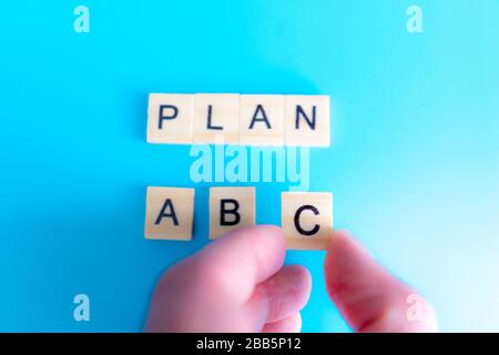 Lettere in legno piano a B C, concetto di business, su sfondo blu, vista dall'alto. Puntamento manuale Foto Stock