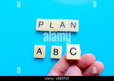 Lettere in legno piano a B C, concetto di business, su sfondo blu, vista dall'alto. Puntamento manuale Foto Stock