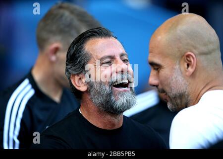 Il responsabile di Watford Quique Sanchez Flores (a sinistra) parla al responsabile di Manchester Pep Guardiola prima dell'inizio della partita Foto Stock