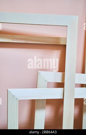 Montature in legno su sfondo rosa. Cornici per foto e dipinti Foto Stock