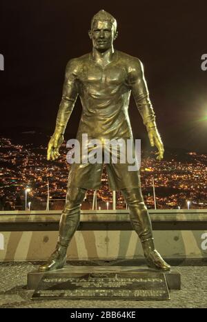 Una vista notturna della statua di Cristiano Ronado più grande della vita fuori dal Museo CR7 sulla Avenida Sá Carneiro al Porto di Funchal, Madeira. Foto Stock