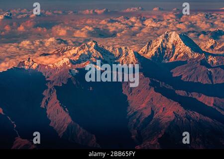 Vista dall'alto delle Ande in nuvole e neve al tramonto Foto Stock