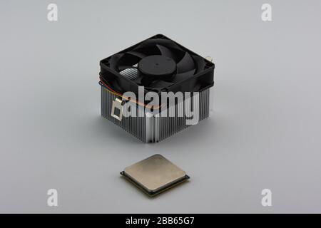 Primo piano dell'unità di elaborazione centrale (CPU) e della ventola di raffreddamento in alluminio isolata su sfondo bianco. Foto Stock