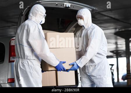 Lavoratori in tute coronavirus Hazmat per la somministrazione di farmaci Foto Stock