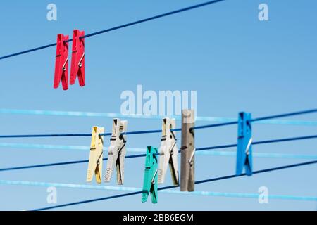 Linee con colorati appendiabiti contro il cielo blu Foto Stock