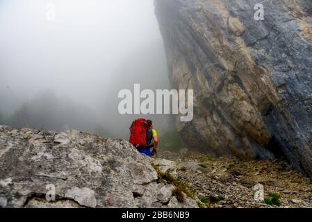 Uomo arrampicata nella nebbia, Ebenalp, Svizzera Foto Stock