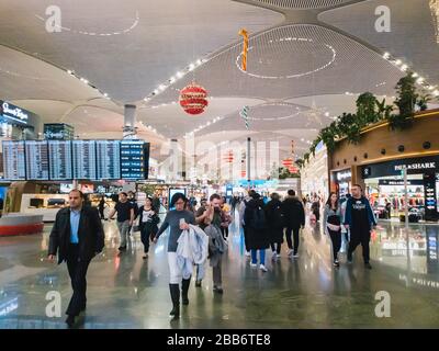 Istanbul, Turchia - 11 febbraio 2020: Passeggeri nella sala partenze del terminal dell'aeroporto IGA di Istanbul, andando alle porte. Decorazione di Natale Foto Stock