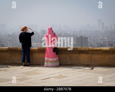 due donne si affacciano sullo skyline del cairo Foto Stock