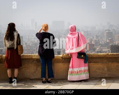 tre donne che si affacciano sullo skyline del cairo Foto Stock