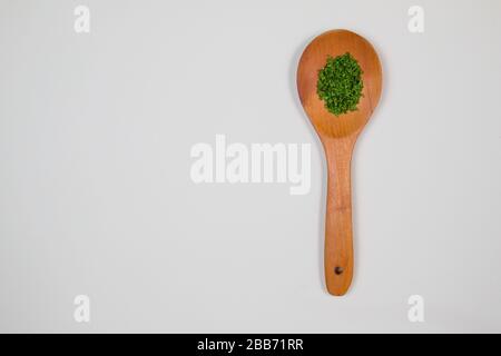 Mestolo di legno con erbe e spezie verdi Foto Stock