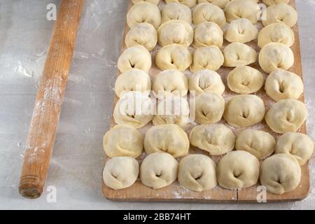Gnocchi russi ripieni di carne macinata con cipolle su un pannello di legno. Foto Stock