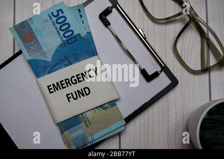 Il testo del Fondo di emergenza e l'indonesiano Rupiah isolato su Office Desk. Foto Stock