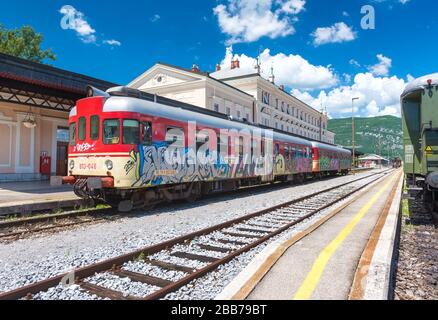 Nova Gorica (Gorizia) - Giugno 2016, Slovenia: Il treno rosso con graffiti si trova sui binari della stazione ferroviaria nella città di Nova Gorica, con vista panoramica Foto Stock