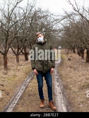 L'uomo in una maschera medica si trova sulla strada. Protezione del virus respiratorio 2019-nCoV, pandemic coronavirus flu, quarantena covid-19. Foto Stock