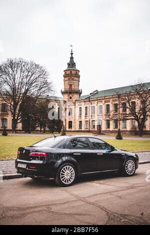 Kiev, Ucraina - 26 gennaio 2020. Alfa Romeo di colore nero sullo sfondo del Politecnico di Kiev Istituto. Nuvole grigie spesse Foto Stock