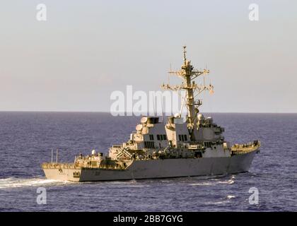 La cacciatorpediniere USS Barry della classe U.S. Navy Arleigh Burke transita con la nave di atterraggio di Whidbey Island USS Germantown 18 marzo 2020 nel Mare delle Filippine. Foto Stock