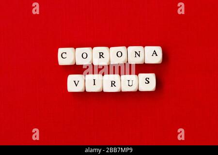 Frase di testo Coronavirus fatta da blocchi di legno, su sfondo rosso. Nuovo coronavirus 2019-nCoV.