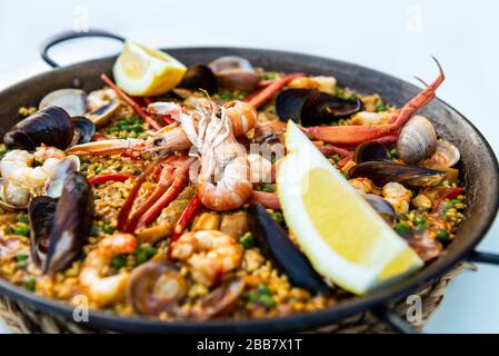 Paella di pesce molto saporita nella padella, cibo tradizionale spagnolo Foto Stock