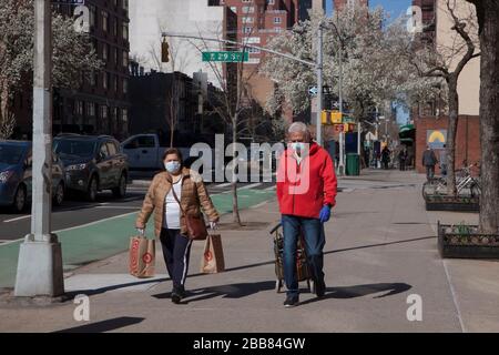 Persone che indossano maschere facciali mentre camminano i marciapiedi di New York City durante l'epidemia di Covid-19 (coronavirus). Foto Stock