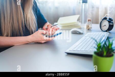 ragazza che usa online banking via smartphone da casa, fuoco selettivo Foto Stock