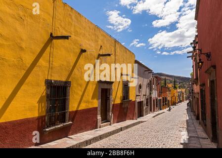 Messico, stato Guanajuato, San Miguel de Allende, edifici di epoca coloniale spagnola che costeggiano una strada Foto Stock