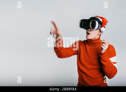 Uomo che indossa la realtà virtuale gli occhiali. Studio shot, backgroun grigio Foto Stock