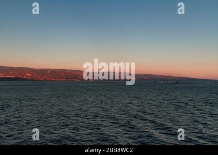 Vista dello Stretto di Messina dal traghetto che la attraversa, con un altro traghetto sullo sfondo Foto Stock