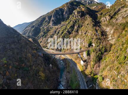 Il fiume di montagna lungo la strada, aereo panoramico drone vista di una strada panoramica dal bellissimo paesaggio coperto di nuvole e nebbia, ponte e. Foto Stock