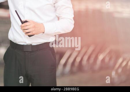 Primo piano Foto di Security Guard Holding Walkie-talkie Foto Stock