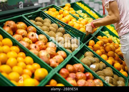Frutta nelle scatole di plastica verdi sul ripiano della drogheria Foto Stock