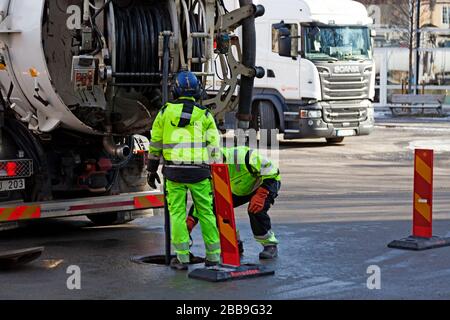 Umea, Norrland Svezia - 25 marzo 2020: Due uomini lavorano con un pozzo vicino all'opera Foto Stock