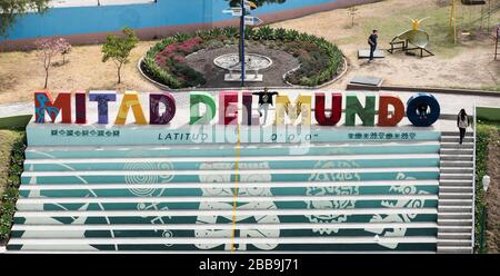 QUITO, ECUADOR - 29 LUGLIO 2018: Un uomo pone per una foto con il segno delle lettere di Mitad del Mundo. Foto Stock