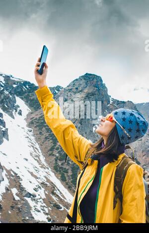 Ricerca di connessione mobile in natura selvaggia in vacanza. Giornata all'aperto perfetta. Donna con smartphone. Paesaggio di montagna di roccia. Donna che fa mobile Foto Stock