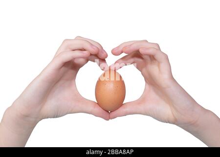 Le mani della donna si collocano in forma di cuore con un uovo biologico, isolato su sfondo bianco. Uovo di pollo da aree ecologicamente pulite Foto Stock