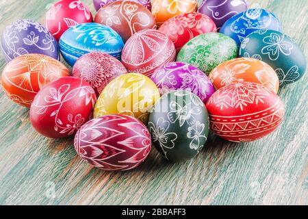 Varietà di colorate uova di pasqua graffiate a mano su tavola di legno Foto Stock