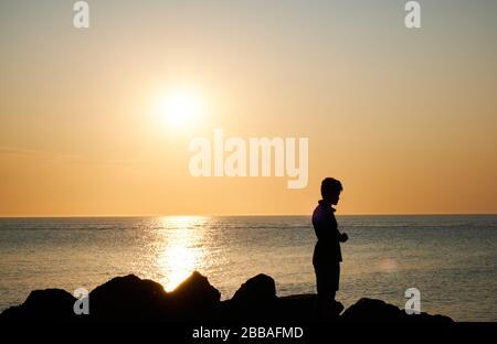 Vista di un'ombra di pescatori sulle rocce della costa di Punta Ballena sulla baia di Solanas, Oceano atlantico, Maldonado, Uruguay Foto Stock