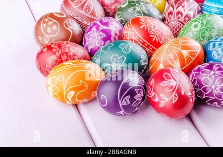 Varietà di colorate uova di pasqua graffiate a mano su tavola di legno Foto Stock