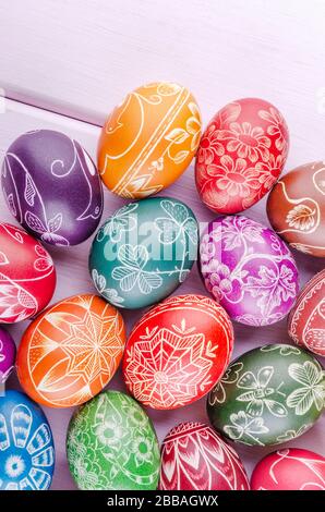 Varietà di colorate uova di pasqua graffiate a mano su tavola di legno Foto Stock